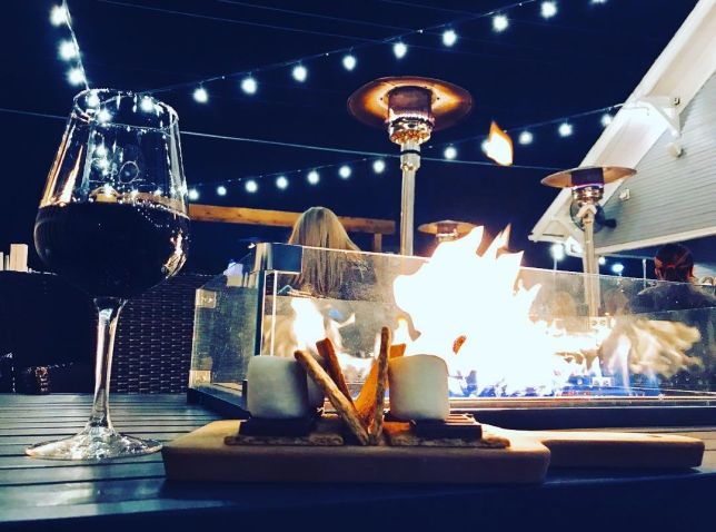 Glass of wine in front of a fire at Eight Eleven place in Frisco, Texas
